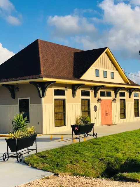 Commercial building re-roofed by ABCO, cream siding under a new brown shingle roof
